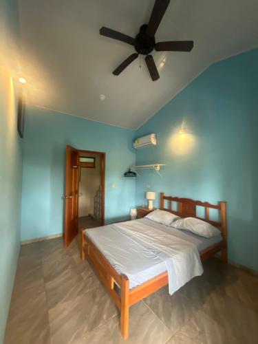 Un dormitorio con una cama con ventilador de techo. en Hostal Casa Las Lajas, en Las Lajas