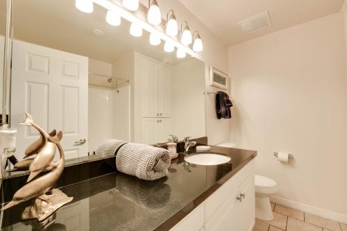 een witte badkamer met een wastafel en een spiegel bij The Electric Blue Abode, Oceanside in Los Angeles