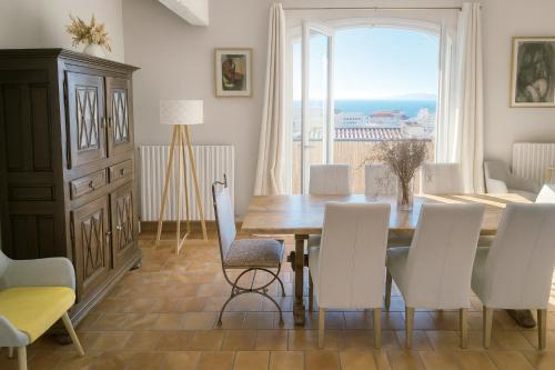 una sala da pranzo con tavolo, sedie e una finestra di Villa Farniente a Sète
