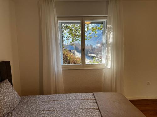 ein Schlafzimmer mit einem Bett und einem Fenster in der Unterkunft Niesenblick apartment in Spiez