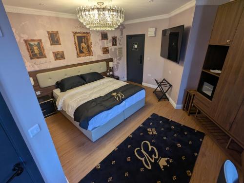 a bedroom with a large bed and a chandelier at Empress Boutique Hotel Suites in Mexborough