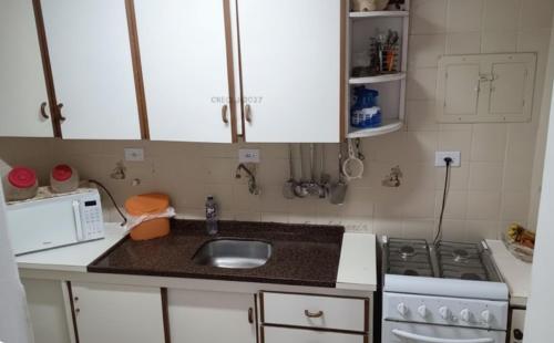 a small kitchen with a sink and a stove at Triplex no Centro e Pertinho da Praia in Guaratuba