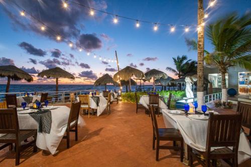 a restaurant on the beach with tables and chairs at Club Regina Cancun in Cancún