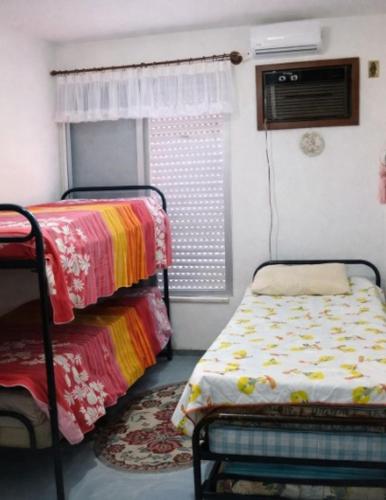 a small room with a bed and a window at Triplex no Centro e Pertinho da Praia in Guaratuba