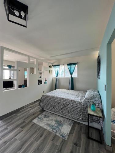 a bedroom with a bed and a wooden floor at Casa Axhé Rosarito in Rosarito Beach