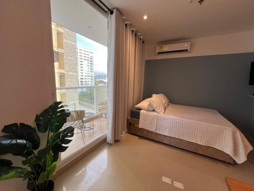 a bedroom with a bed and a large window at Edificio Eira in Santa Marta