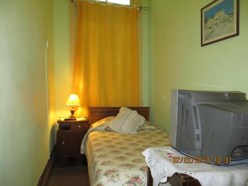 a bedroom with a tv sitting on a bed at Hostal El Rincon Marino in Valparaíso