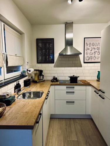 a kitchen with white cabinets and a sink at Ons huisje in Schoot in Budel-Schoot