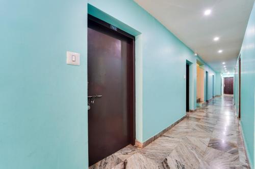 un corridoio con pareti blu e una porta marrone di Super Hotel O Kanyakumari Near Sunrise View formerly Jaisas Paradise a Kanyakumari