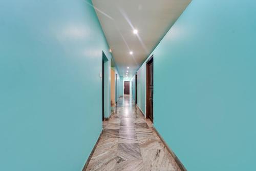 un corridoio con pareti blu e pavimenti in legno di Super Hotel O Kanyakumari Near Sunrise View formerly Jaisas Paradise a Kanyakumari