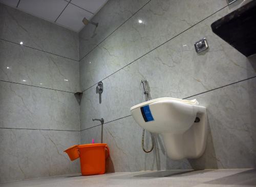 une salle de bains avec un urinoir et une poubelle orange dans l'établissement KRUSHNA Boarding And Lodging, à Belmannu