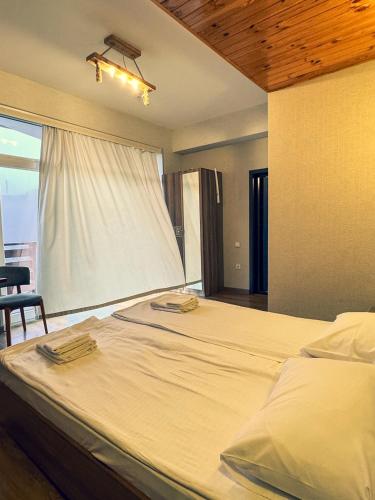 a large bed in a bedroom with a window at MAER'S Hotel in Qusar
