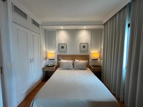 a bedroom with a large bed with two night stands at Flat Hotel Pamplona Jardins Univer com garagem 2402 in Sao Paulo