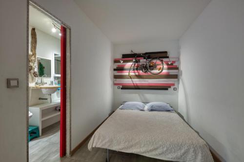 une petite chambre avec un lit et un miroir dans l'établissement Studio NEW YORK, à Alignan-du-Vent