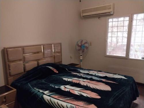 a bedroom with a bed and a fan and a window at مصر مدينة الشيخ زايد in Sheikh Zayed