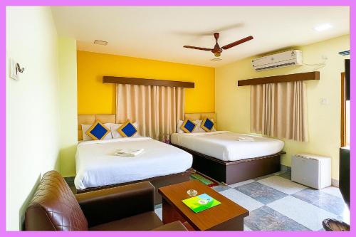 ein Hotelzimmer mit zwei Betten und einer Couch in der Unterkunft Hotel Coral Premium Suite Near Jagannath Temple - Sea Beach - Lift Free Parking & Swimming Pool - Best Prime Location Hotel in Puri