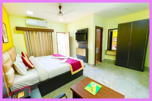 ein Hotelzimmer mit Bett und Fernseher in der Unterkunft Hotel Coral Premium Suite Near Jagannath Temple - Sea Beach - Lift Free Parking & Swimming Pool - Best Prime Location Hotel in Puri