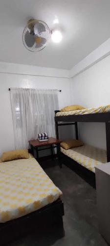 a room with three bunk beds and a table at Ma Fremie's Hometel in Lal-lo