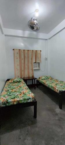 a room with two beds and a window in it at Ma Fremie's Hometel in Lal-lo