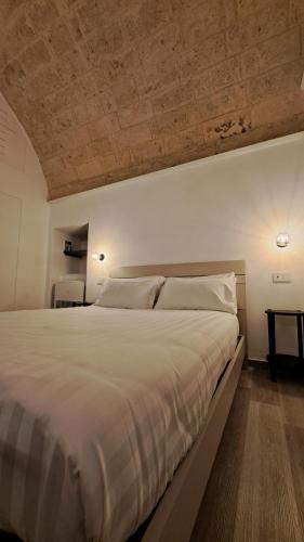 una camera da letto con un grande letto bianco e un soffitto di Il porto è di casa a Trani