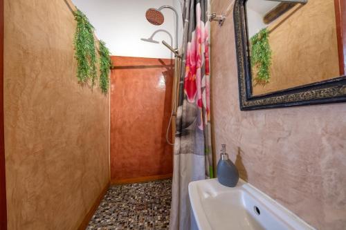 een badkamer met een wastafel, een spiegel en een bad bij Bien-être in Alignan-du-Vent