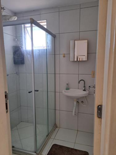 een badkamer met een glazen douche en een wastafel bij Ilhéus in Ilhéus