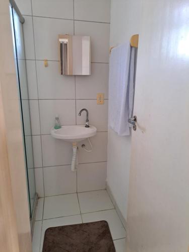 een kleine badkamer met een wastafel en een douche bij Ilhéus in Ilhéus