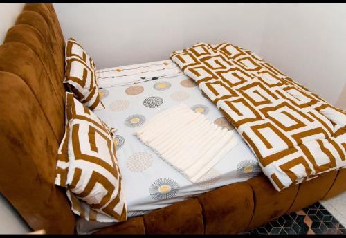 a brown couch with a blanket on top of it at Lumora Deluxe Apartment in Tanga