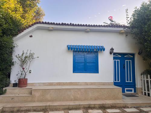 una casa bianca con porte e scale blu di iBiZa Hostel a Beni Suef