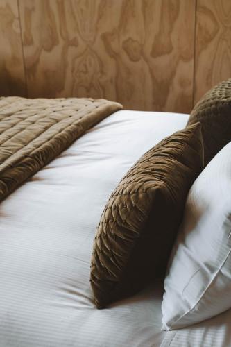 a close up of a bed with a pillow on it at Tukare Cabins in Te Anau