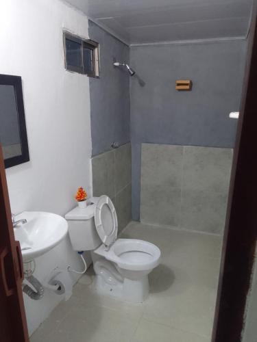 a bathroom with a white toilet and a sink at Apart Cabaña KTIK in San Bernardo del Viento
