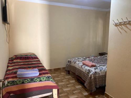 una camera da letto con due letti in una stanza di Hostal las Margaritas a Salta