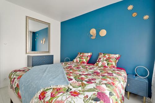 a bedroom with a bed with a blue wall at Appartement Dinard hyper centre, 2 chambres in Dinard