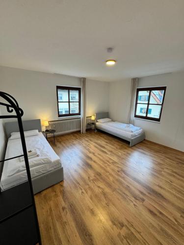 a bedroom with two beds and a wooden floor at Bavaria Home Apartments in Rohrbach