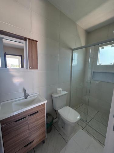 a bathroom with a toilet and a sink and a shower at Residencial Lara 9 in Itapema
