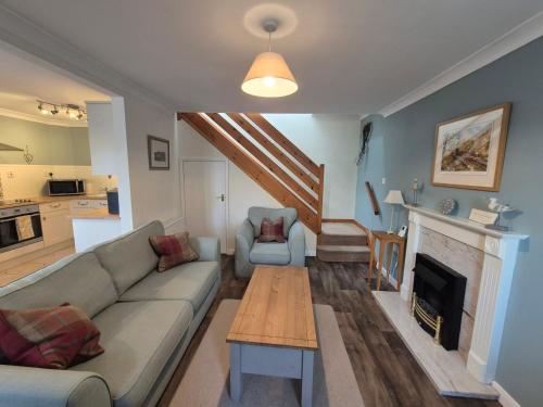 een woonkamer met een bank en een open haard bij Westgate Cottage in Pickering