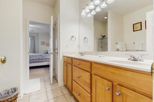 un bagno con un lavandino e un grande specchio di Bear Trap Dunes 53D Willow Oak Ave a Ocean View
