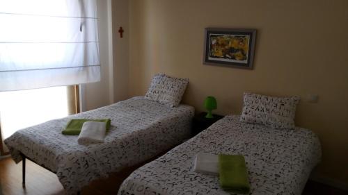1 dormitorio con 2 camas y ventana en VRS - PORTO BEACH FLAT, en Oporto