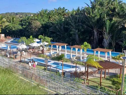 un complexe hôtelier avec une piscine où des gens se promènent dans l'établissement Apartamento em Resort no Litoral sul, à Parnamirim