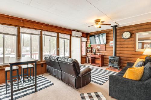 a living room with leather furniture and a table at Hike and Ski Log Cabin in East Stroudsburg! in East Stroudsburg