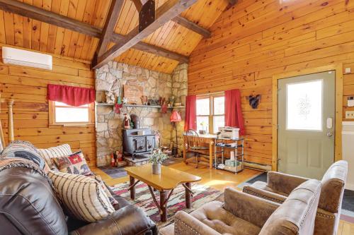 a living room with leather furniture and a stone fireplace at Hike and Ski Log Cabin in East Stroudsburg! in East Stroudsburg
