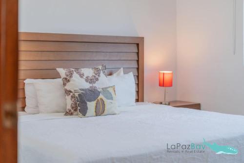 una camera con letto bianco e cuscini di Beautiful House 3 Floors BBQ and Relaxation a La Paz