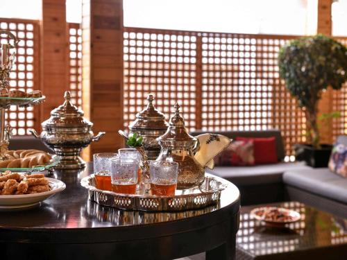 Una mesa con una bandeja de té y vasos encima. en Mercure Shéhérazade Rabat, en Rabat