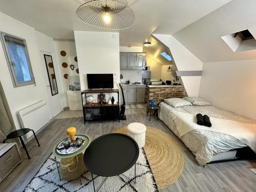 a room with a bed and a table and a kitchen at Le Comfy Studio Central proche Disney & Paris in Lagny