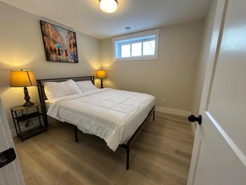 een slaapkamer met een groot bed en een raam bij Bright & cozy apartment in Moncton