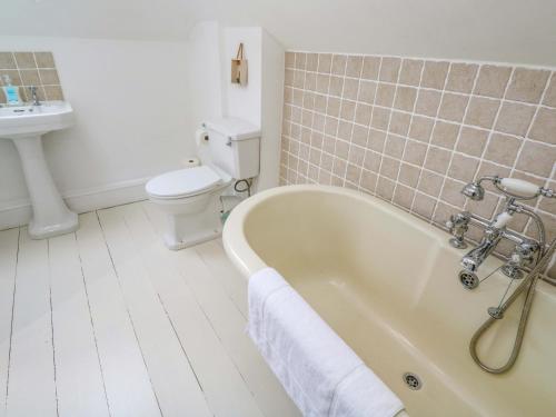 a bathroom with a tub and a toilet and a sink at Badgers Loft in Penzance