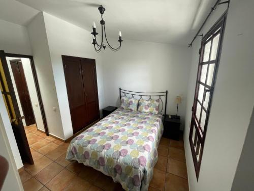 una camera da letto con un letto e un lampadario di Olivia’s house a Maspalomas