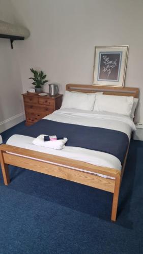 a bedroom with a bed with a wooden frame at Supported Guest rooms near Fratton Park in Portsmouth