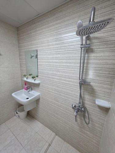 a bathroom with a shower and a sink and a shower at Opera43 Spacious & Central in Ghubrah