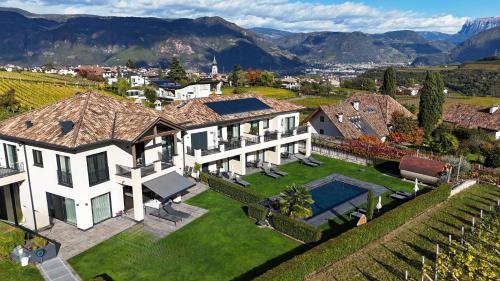an aerial view of a mansion with mountains in the background at Weingut Gasshof- Panorama Pool in den Weinbergen in Appiano sulla Strada del Vino